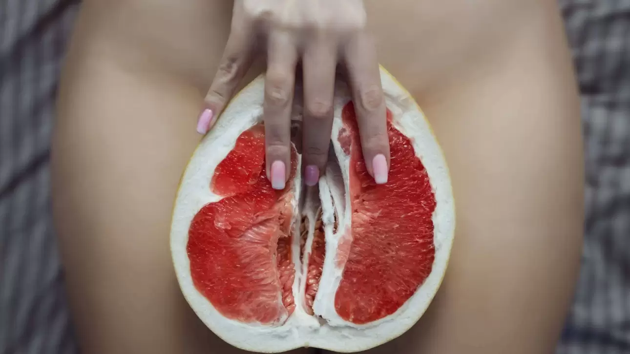 Masaj Yoni pentru femei – simbol erotic cu grapefruit și degete feminine, reprezentare artistică a masajului intim erotic la salonul VIP Zone București