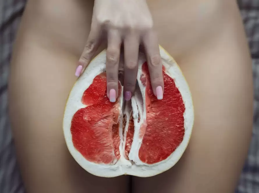 Masaj Yoni pentru femei – simbol erotic cu grapefruit și degete feminine, reprezentare artistică a masajului intim erotic la salonul VIP Zone București